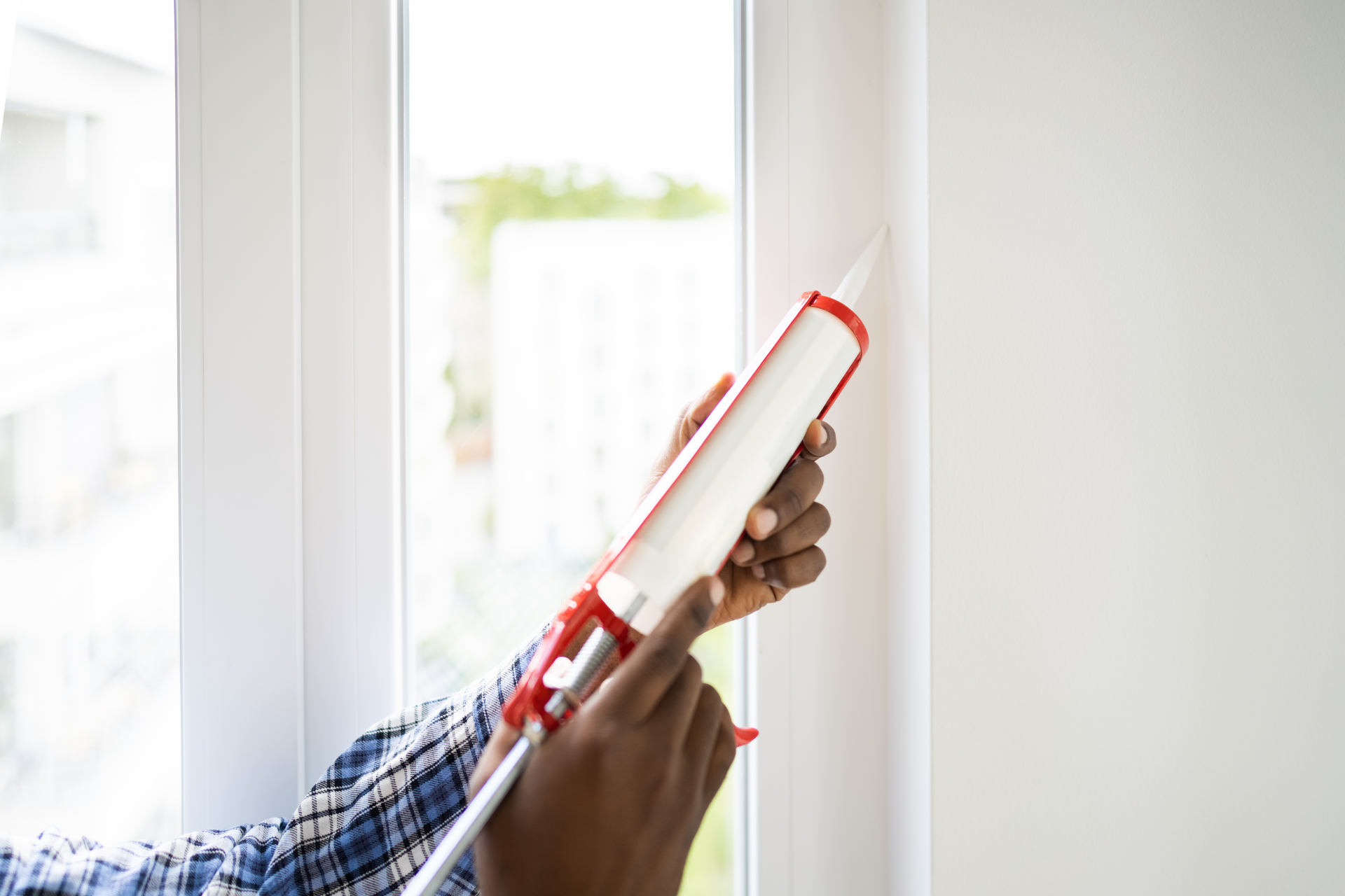 man caulking window